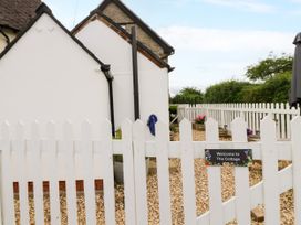 An outdoor area with a white fence and a sign at The Cottage in Ettington