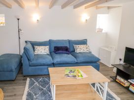 A living room with a blue sofa and coffee table at The Cottage in Ettington