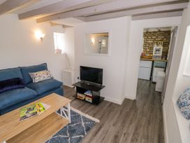 A living room with a sofa, coffee table, and television at The Cottage in Ettington