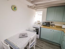 A kitchen with a dining table and stove at The Cottage in Ettington