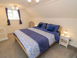 A bedroom with a bed and nightstand at The Cottage in Ettington