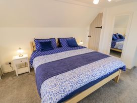 A bedroom with a bed and nightstand at The Cottage in Ettington
