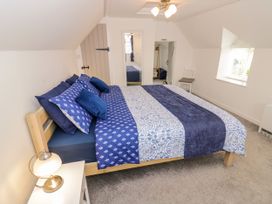 A bedroom with a large bed and mirrors at The Cottage in Ettington