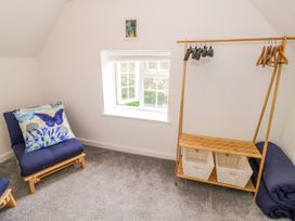 A room with two chairs and a hanger with baskets at The Cottage in Ettington