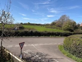 A field with cows and a road sign at The Cottage in Ettington