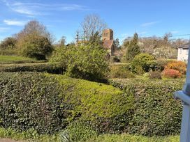 A view of hedges and trees near a building at The Cottage in Ettington