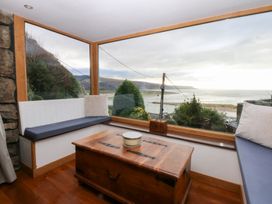 A snug with a table and benches at Ty'n-Y-Ffynnon Cottage in Barmouth