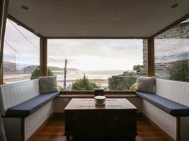 A conservatory with seating and a view at Ty'n-Y-Ffynnon Cottage in Barmouth