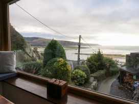 A view from a window showing the beach and sea at Ty'n-Y-Ffynnon Cottage in Barmouth