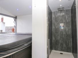 A bathroom with a hot tub and a shower at Ty'n-Y-Ffynnon Cottage in Barmouth