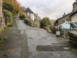 An outdoor view of a sloped road with houses and plants at Ty'n-Y-Ffynnon Cottage in Barmouth