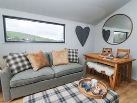 A living room with a sofa and dining table at Fawn’s Rest in Nantmel near Rhayader