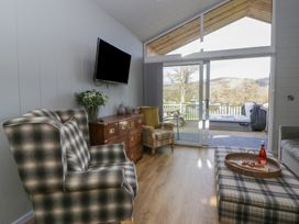 A living room with a sofa and television at Doe Lodge in Nantmel near Rhayader