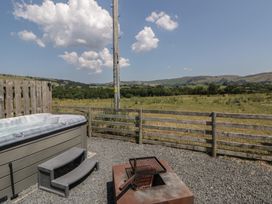 An outdoor area with a hot tub and fire pit at Tin Shed in Nantmel near Rhayader