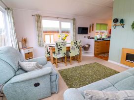 A living room with a dining area and kitchen at Daffodil Lodge Mullacott near Ilfracombe