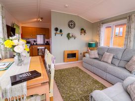 A living room with a dining table and couch at Daffodil Lodge near Ilfracombe