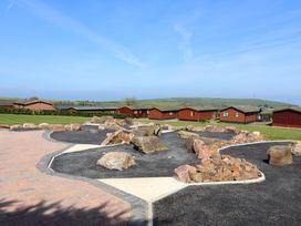 An outdoor area with lodges and rocks at Daffodil Lodge in Mullacott near Ilfracombe