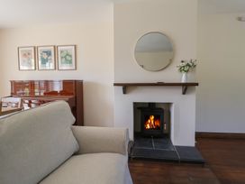 A living room with a piano and fireplace at 10 The Gardens Rousdon near Lyme Regis