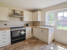 A kitchen with cabinets, oven, sink and kettle at 10 The Gardens Rousdon near Lyme Regis