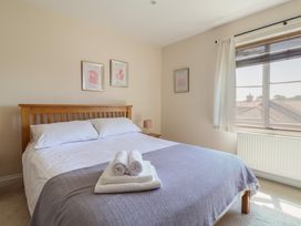 A bedroom with a bed and window at 10 The Gardens in Rousdon near Lyme Regis