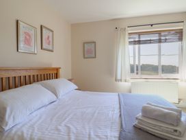 A bedroom with a bed and window at 10 The Gardens in Rousdon near Lyme Regis