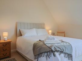 A bedroom with a bed and bedside lamp at 10 The Gardens in Rousdon near Lyme Regis