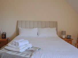 A bedroom with a bed and towels folded on it at 10 The Gardens Rousdon near Lyme Regis