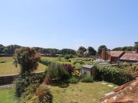 A garden with a shed and house at 10 The Gardens Rousdon near Lyme Regis