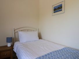 A bedroom with a bed and lamp at 10 The Gardens, Rousdon near Lyme Regis
