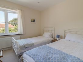 A bedroom with two beds and a window at 10 The Gardens Rousdon near Lyme Regis