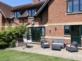 A patio with outdoor seating and a hammock chair at 10 The Gardens Rousdon near Lyme Regis