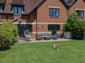 A house with patio furniture and a dog in the garden at 10 The Gardens Rousdon near Lyme Regis