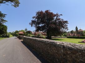 A view of a road alongside a stone wall and buildings at 10 The Gardens Rousdon near Lyme Regis
