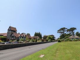 An outdoor area with a building and trees at 10 The Gardens in Rousdon near Lyme Regis