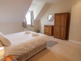 A bedroom with a bed, dresser, and wardrobe at 10 The Gardens in Rousdon near Lyme Regis
