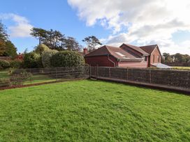 A garden with grass and a fence at 10 The Gardens Rousdon near Lyme Regis