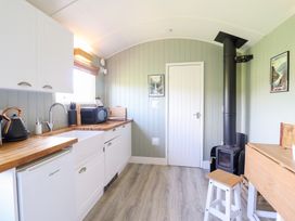 A kitchen with cabinets and a stove at Cuckoo at Wild Valley Huts in Llanrhaeadr-Ym-Mochnant