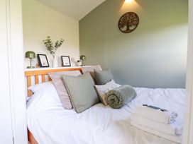 A bedroom with a bed and decorative elements at Cuckoo at Wild Valley Huts Llanrhaeadr-Ym-Mochnant