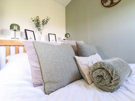 A bedroom with a bed and decorative pillows at Cuckoo at Wild Valley Huts Llanrhaeadr-Ym-Mochnant