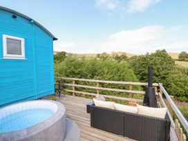 An outdoor area with a hot tub and seating at Cuckoo at Wild Valley Huts in Llanrhaeadr-Ym-Mochnant
