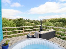 An outdoor area with a hot tub and seating at Cuckoo at Wild Valley Huts Llanrhaeadr-Ym-Mochnant