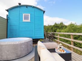 An outdoor seating area with a hot tub and table at Cuckoo at Wild Valley Huts in Llanrhaeadr-Ym-Mochnant