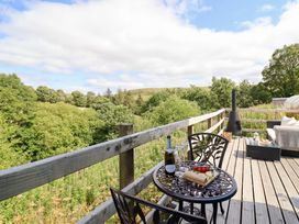 An outdoor seating area with a table and chairs at Cuckoo at Wild Valley Huts Llanrhaeadr-Ym-Mochnant