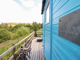 A deck with a table and chairs at Cuckoo at Wild Valley Huts Llanrhaeadr-Ym-Mochnant