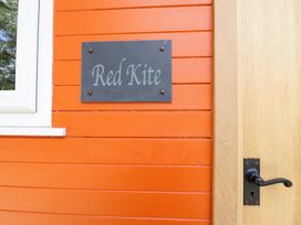 A sign labeled Red Kite on an orange wall at Red Kite at Wild Valley Huts in Llanrhaeadr-Ym-Mochnant