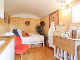 A bedroom with a bed and a table at Red Kite at Wild Valley Huts Llanrhaeadr-Ym-Mochnant