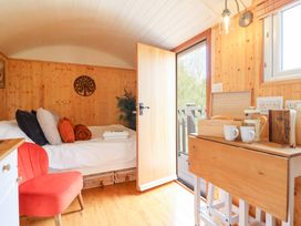 A bedroom with a bed and a table with mugs and bread at Red Kite at Wild Valley Huts Llanrhaeadr-Ym-Mochnant