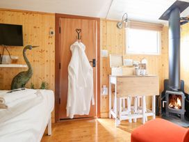 An indoor photo of a room with a fireplace and a table at Red Kite at Wild Valley Huts Llanrhaeadr-Ym-Mochnant
