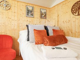 A bedroom with a bed and pillows at Red Kite at Wild Valley Huts in Llanrhaeadr-Ym-Mochnant