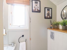 A bathroom with a sink and wall art at Red Kite at Wild Valley Huts Llanrhaeadr-Ym-Mochnant